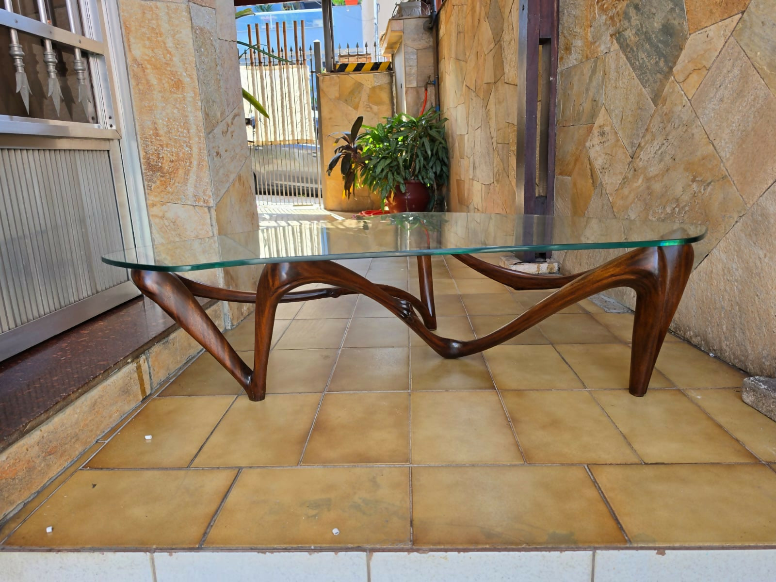 Mesa de centro orgânica anos 50 com base em madeira esculpida e tampo de vidro