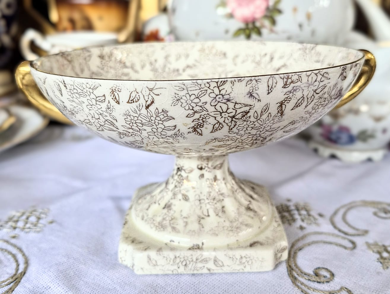 Fruteira pedestal lindíssima em porcelana inglesa, anos 40, Empire Porcelain Co. Decorada com linda cena galante no centro e estampa Gold Chintz em douração em cima do fundo marfim.  Maravilhosa!