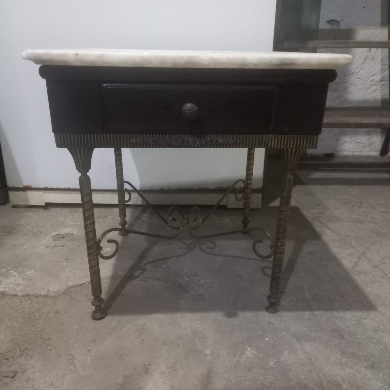 Mesa de cabeceira preta com pés em ferro e tampo em pedra 