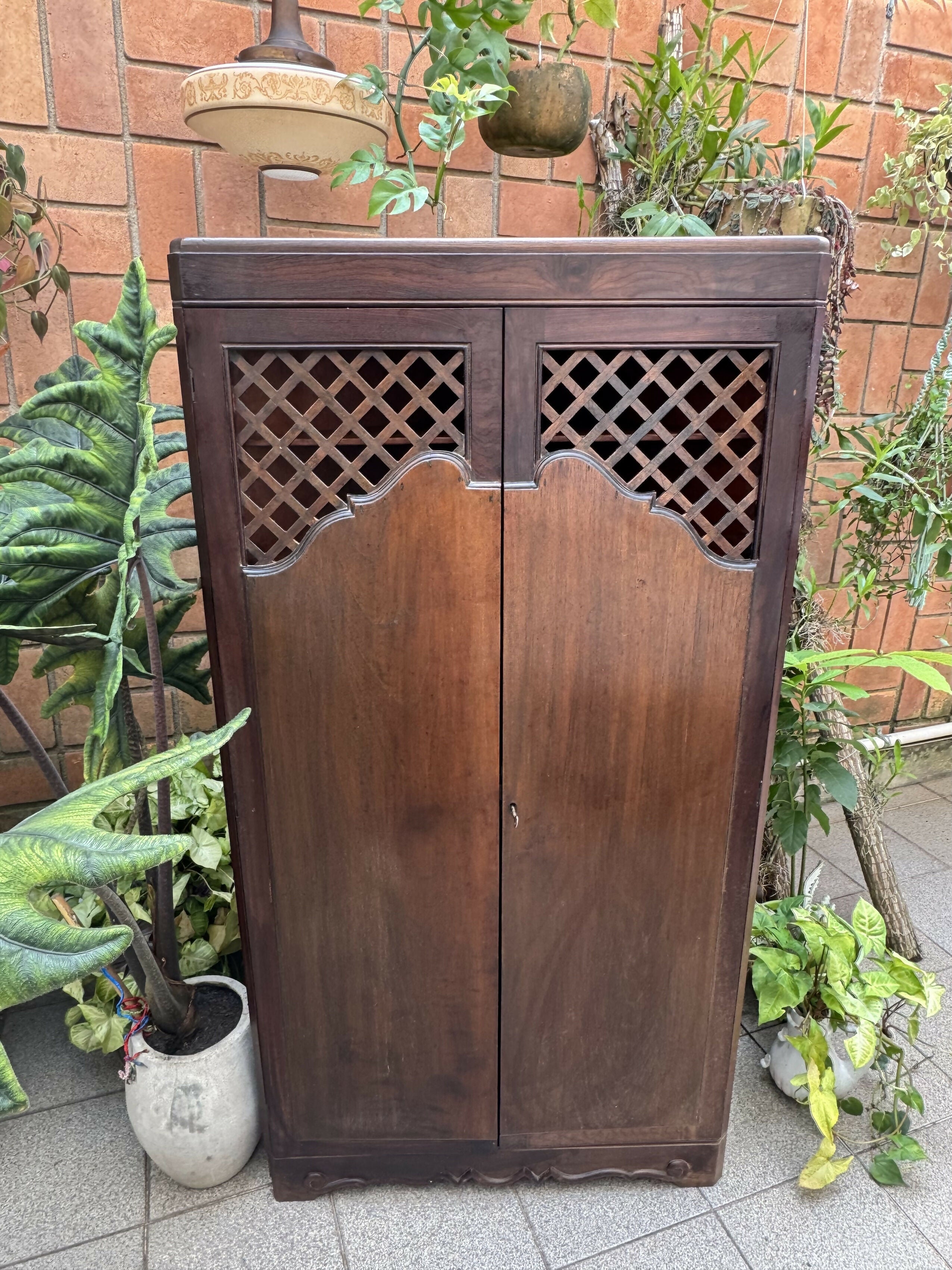 Antigo armário de canto esculpido e com treliças