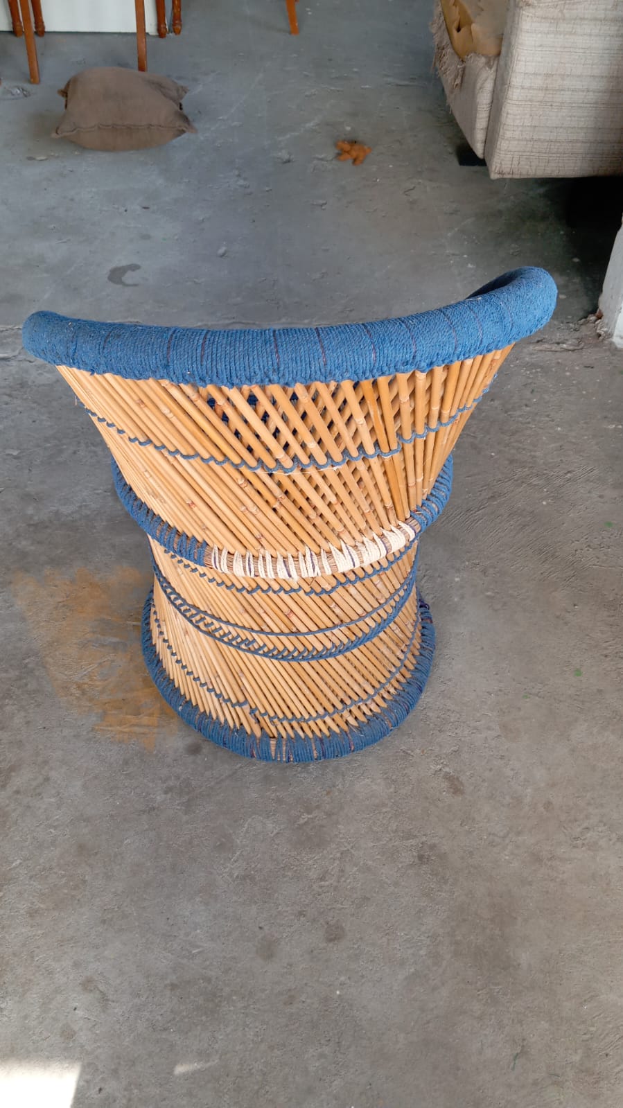 Cadeira arredondada de bambu com tecido crochê azul 