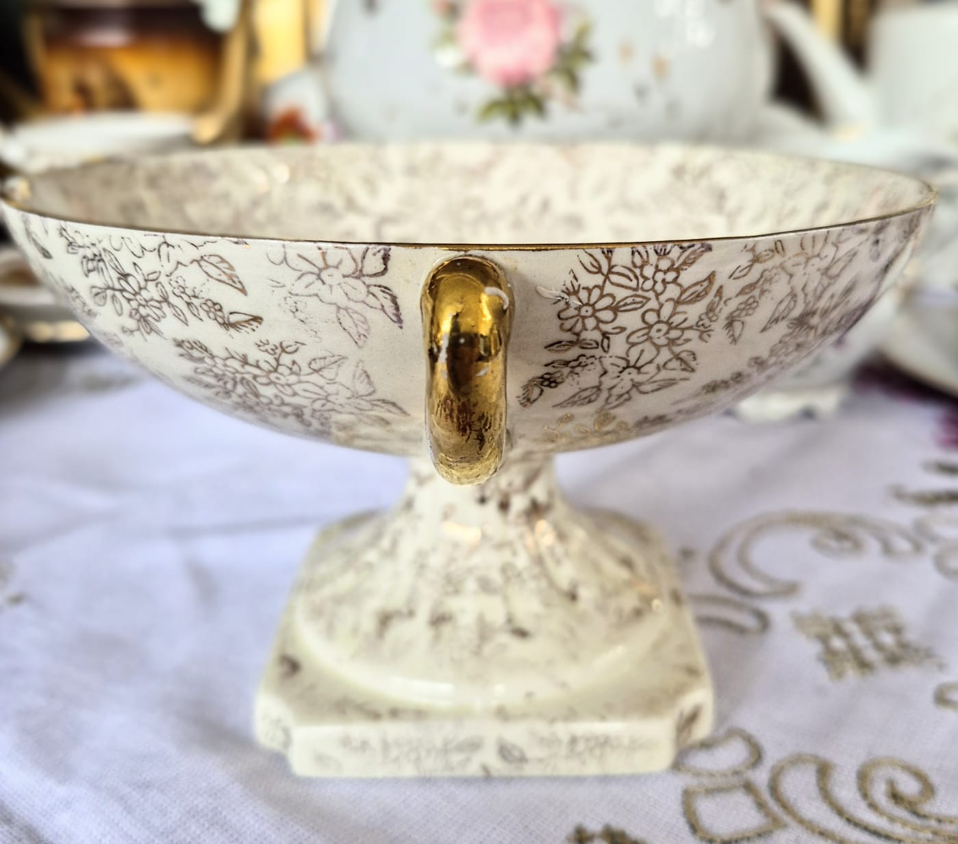 Fruteira pedestal lindíssima em porcelana inglesa, anos 40, Empire Porcelain Co. Decorada com linda cena galante no centro e estampa Gold Chintz em douração em cima do fundo marfim.  Maravilhosa!
