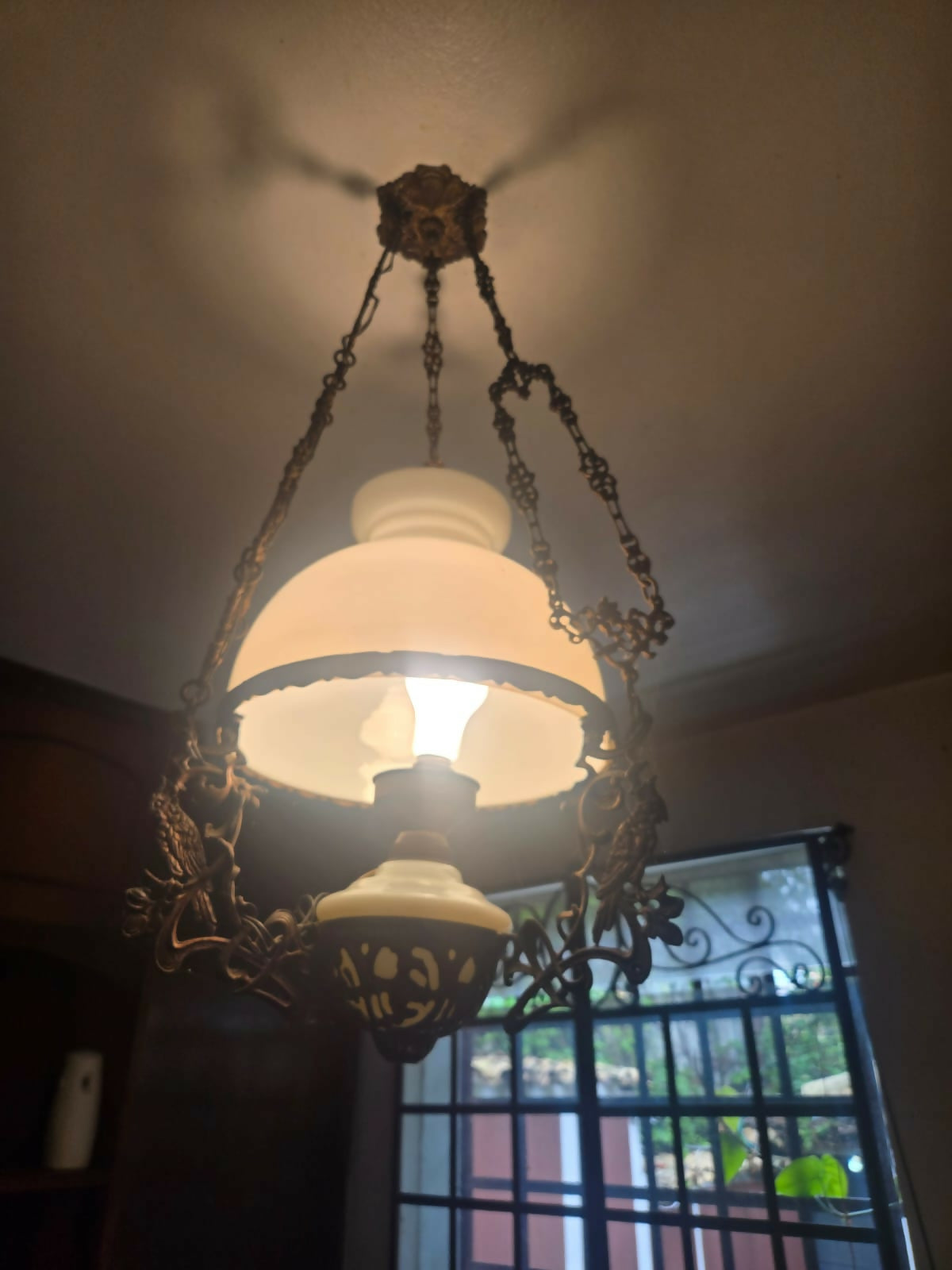 Grande lustre antigo em metal com cúpula de vidro leitoso e detalhe em cacatua