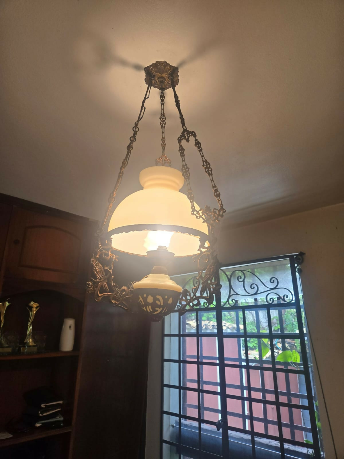 Grande lustre antigo em metal com cúpula de vidro leitoso e detalhe em cacatua