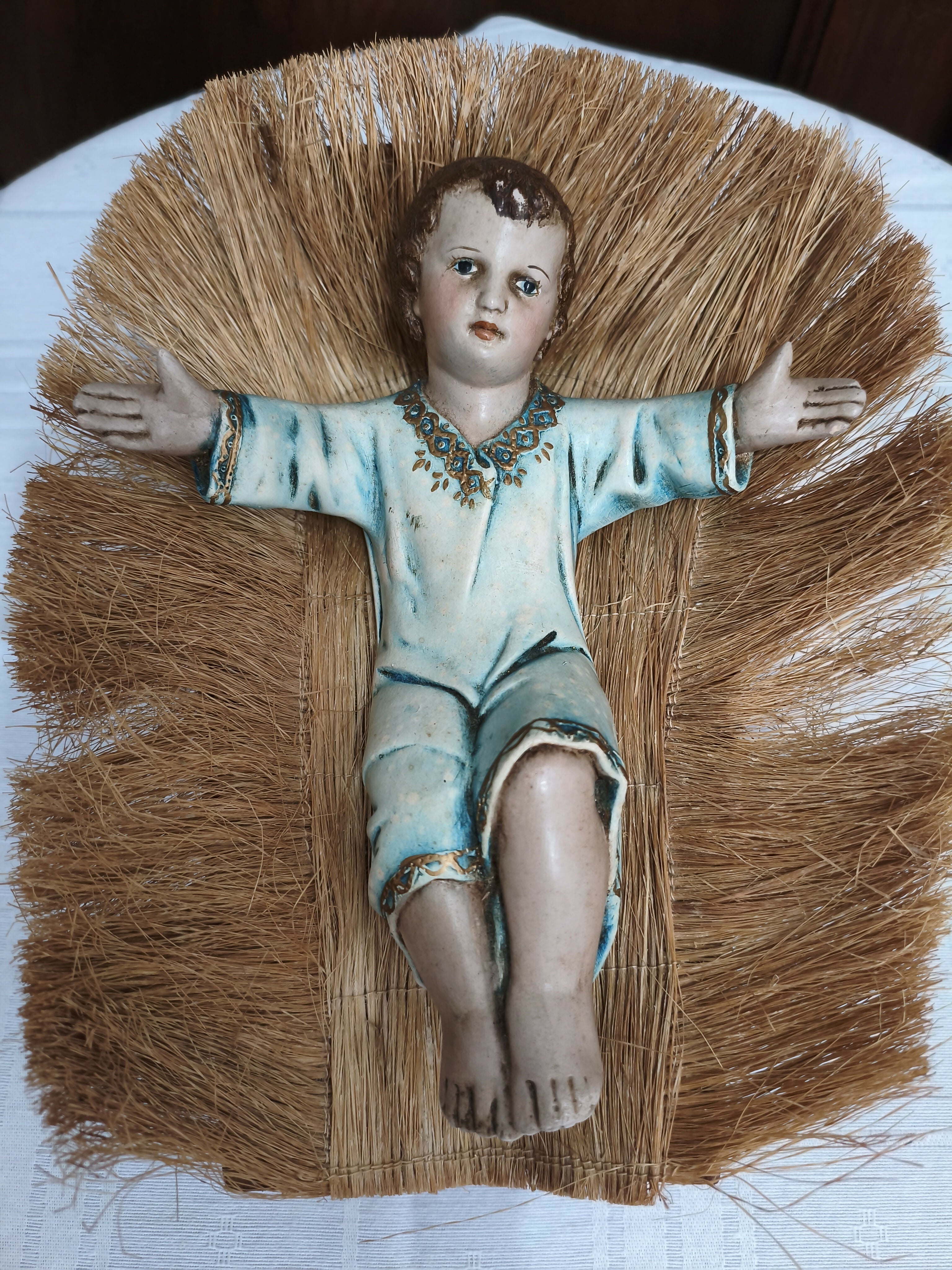 Menino Jesus em gesso com manjedoura de palha