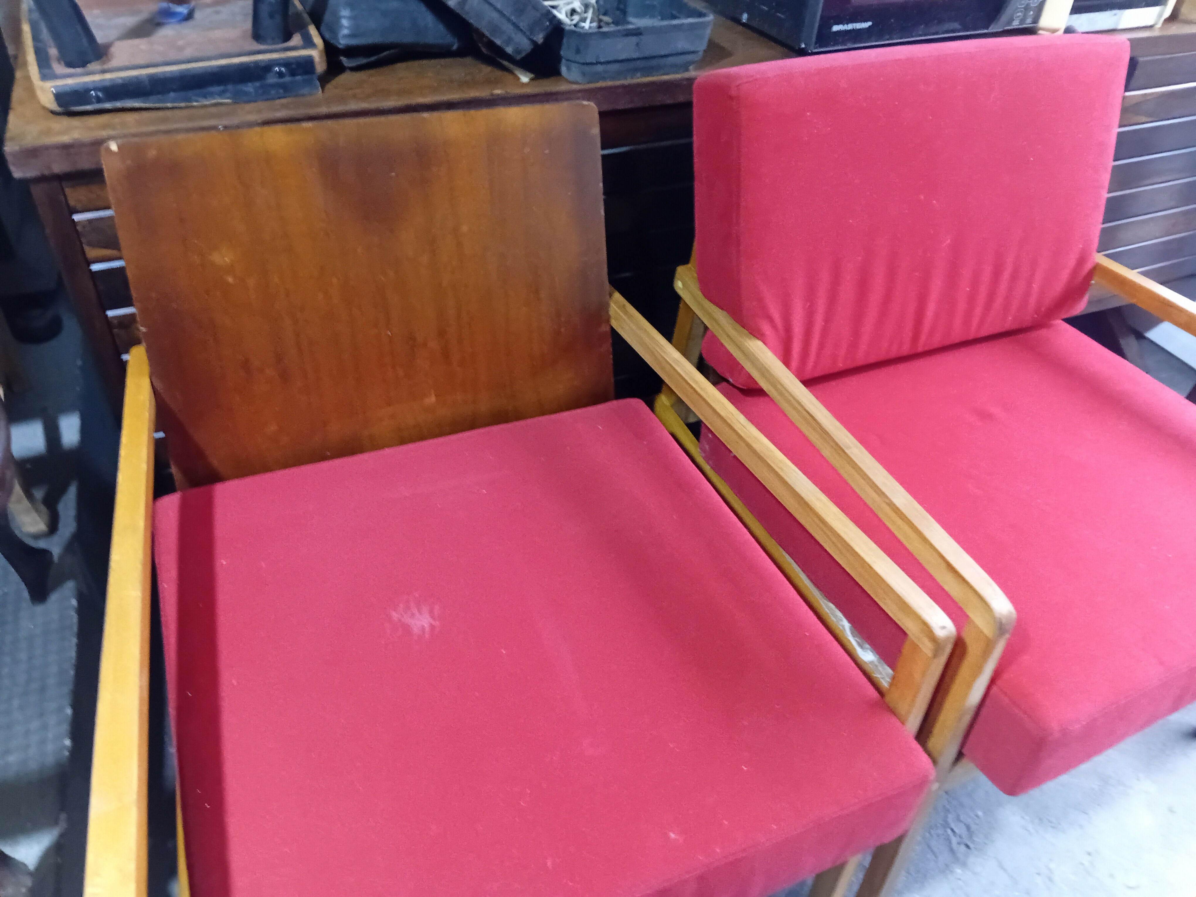 Par de poltronas em madeira clara com almofada vermelha