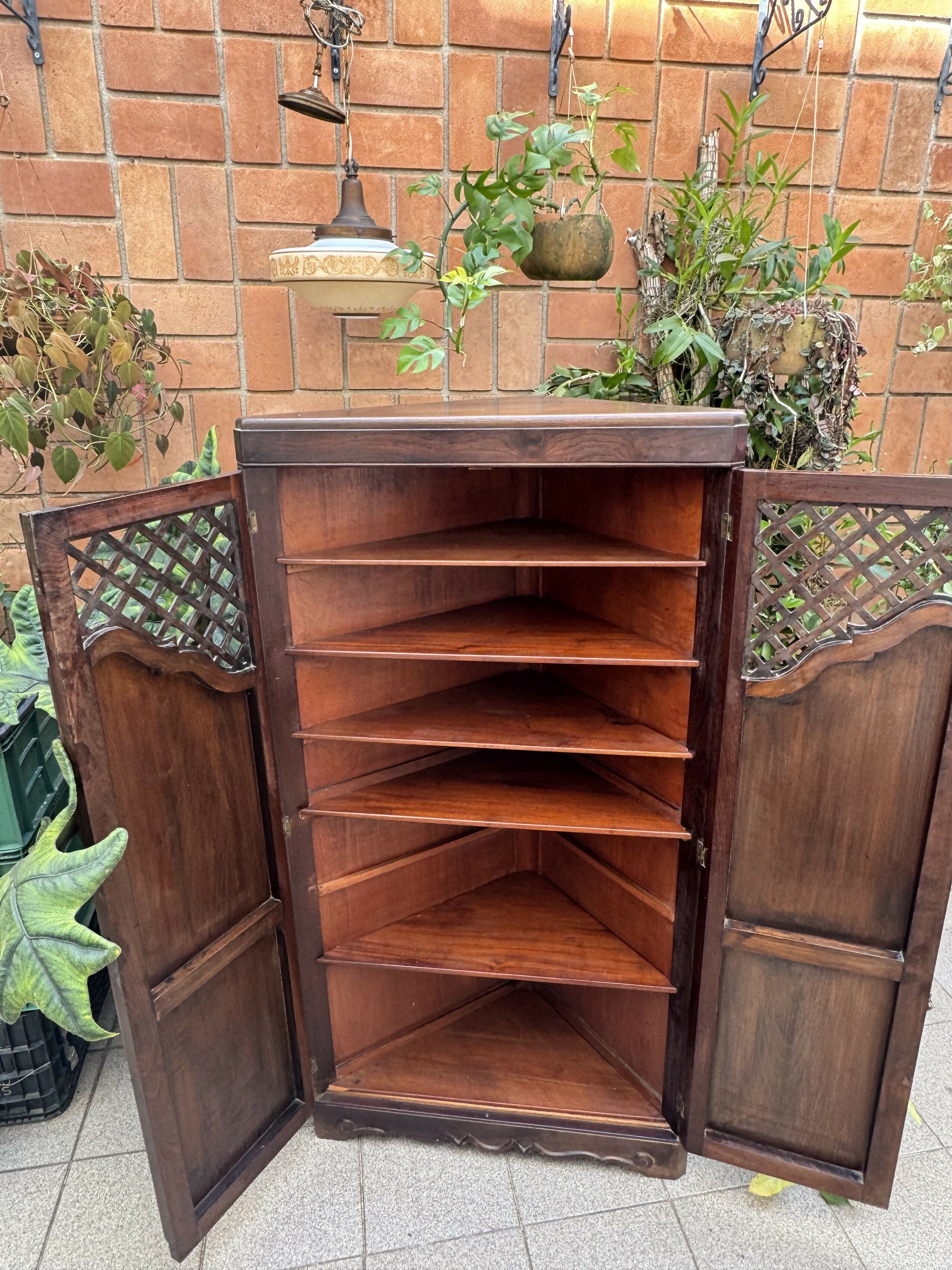 Antigo armário de canto esculpido e com treliças