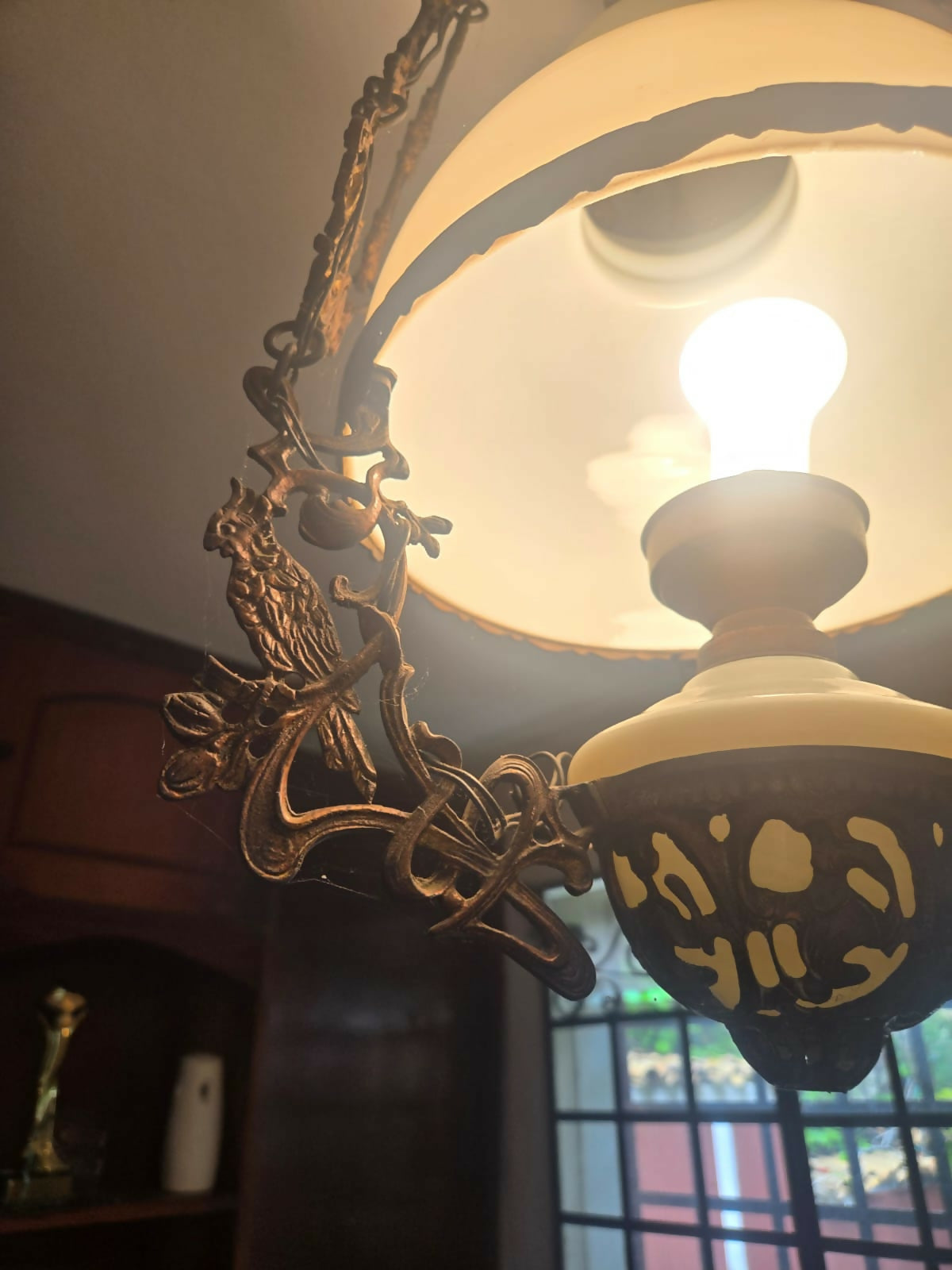 Grande lustre antigo em metal com cúpula de vidro leitoso e detalhe em cacatua