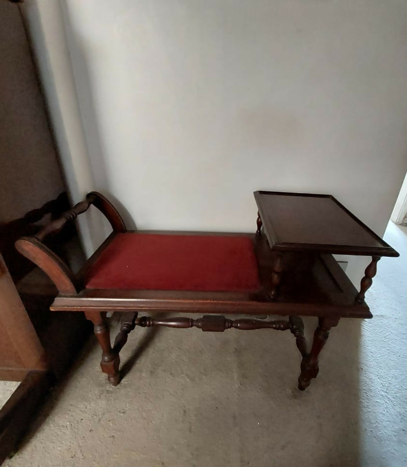 Banqueta de telefone antiga com tecido avermelhado