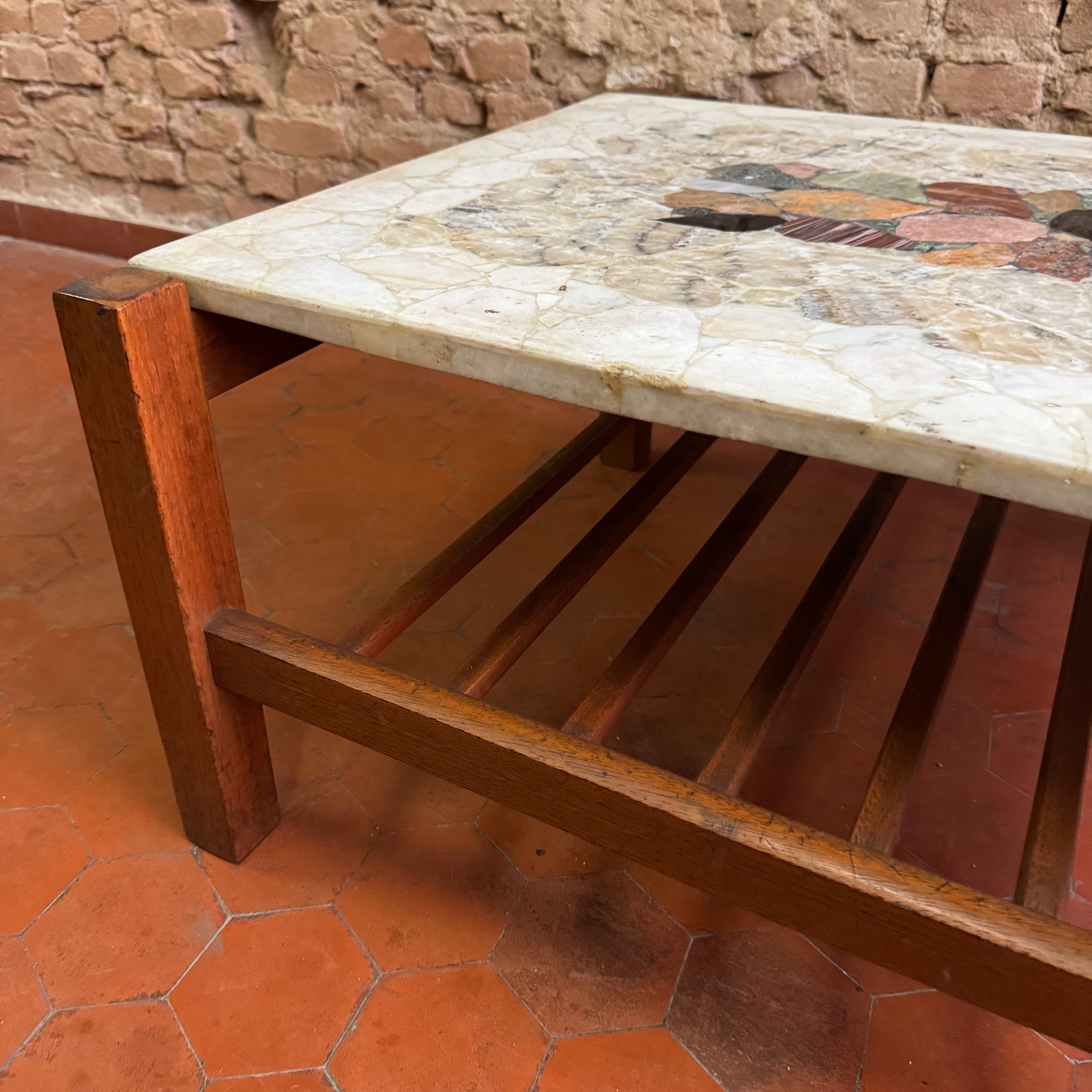 Mesa de centro em madeira com prateleira ripada e tampo em pedras variadas - anos 60