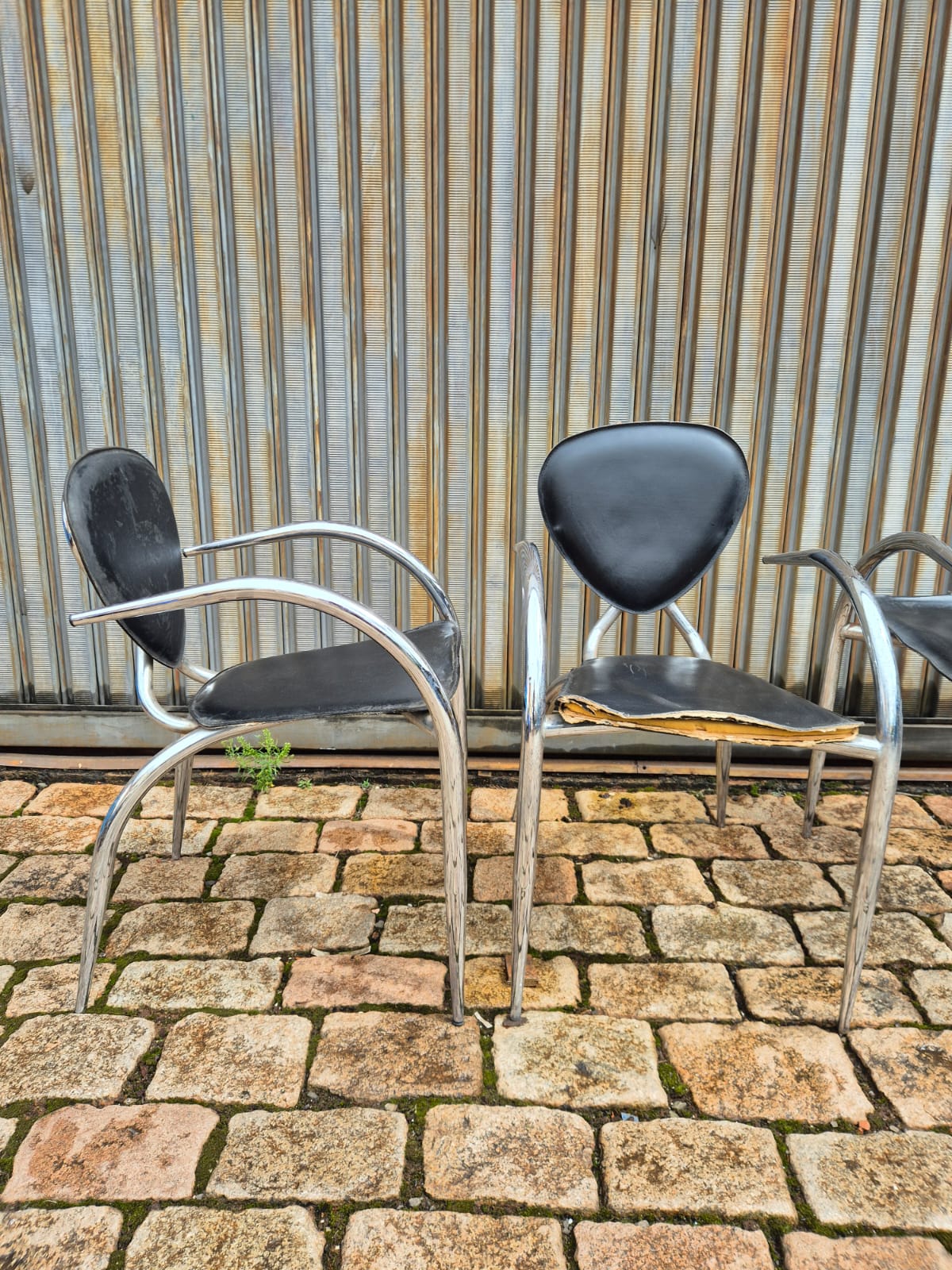 Cadeiras de Design Italiano com linhas curvas em metal tubular e assento preto 