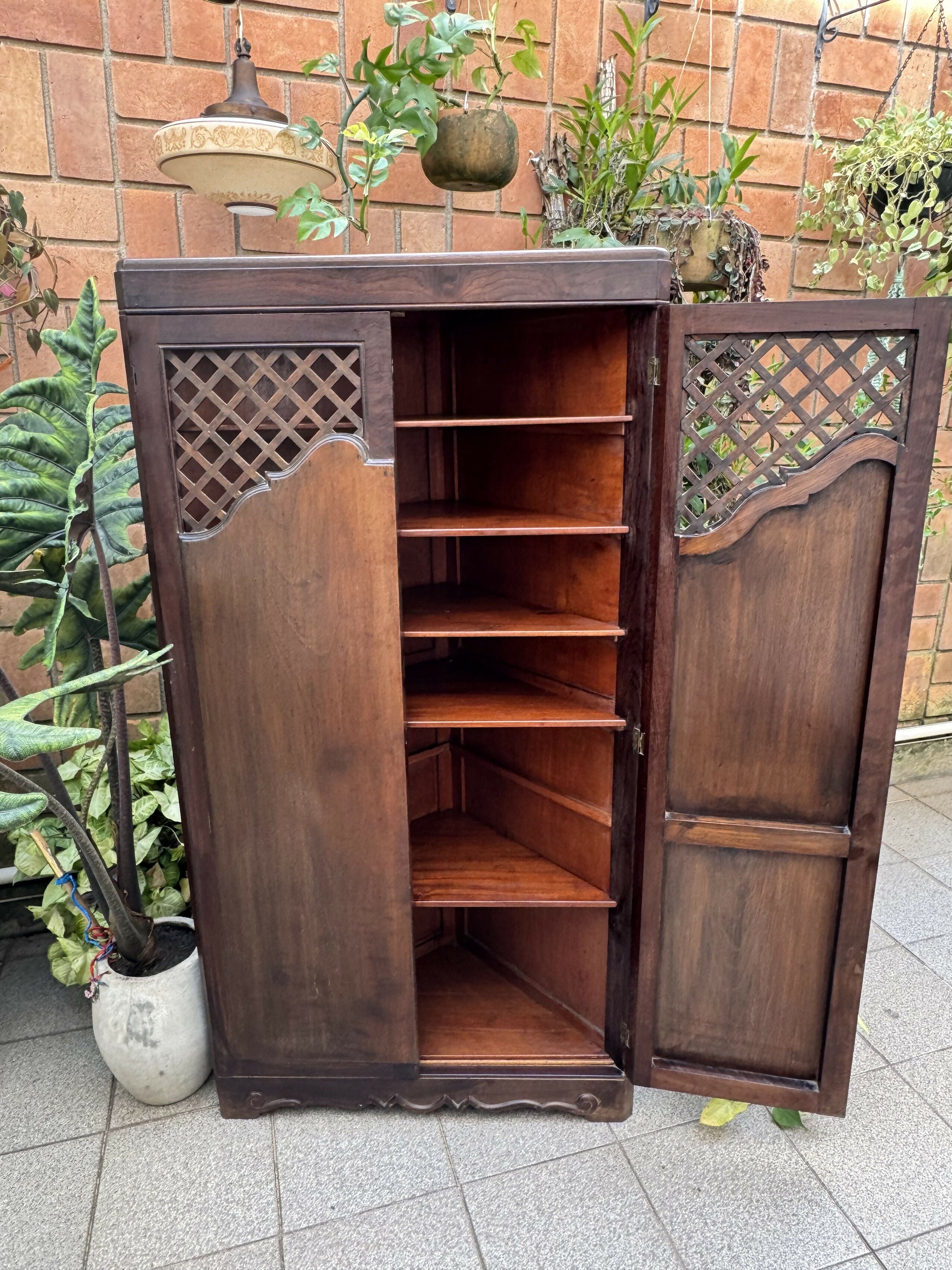 Antigo armário de canto esculpido e com treliças