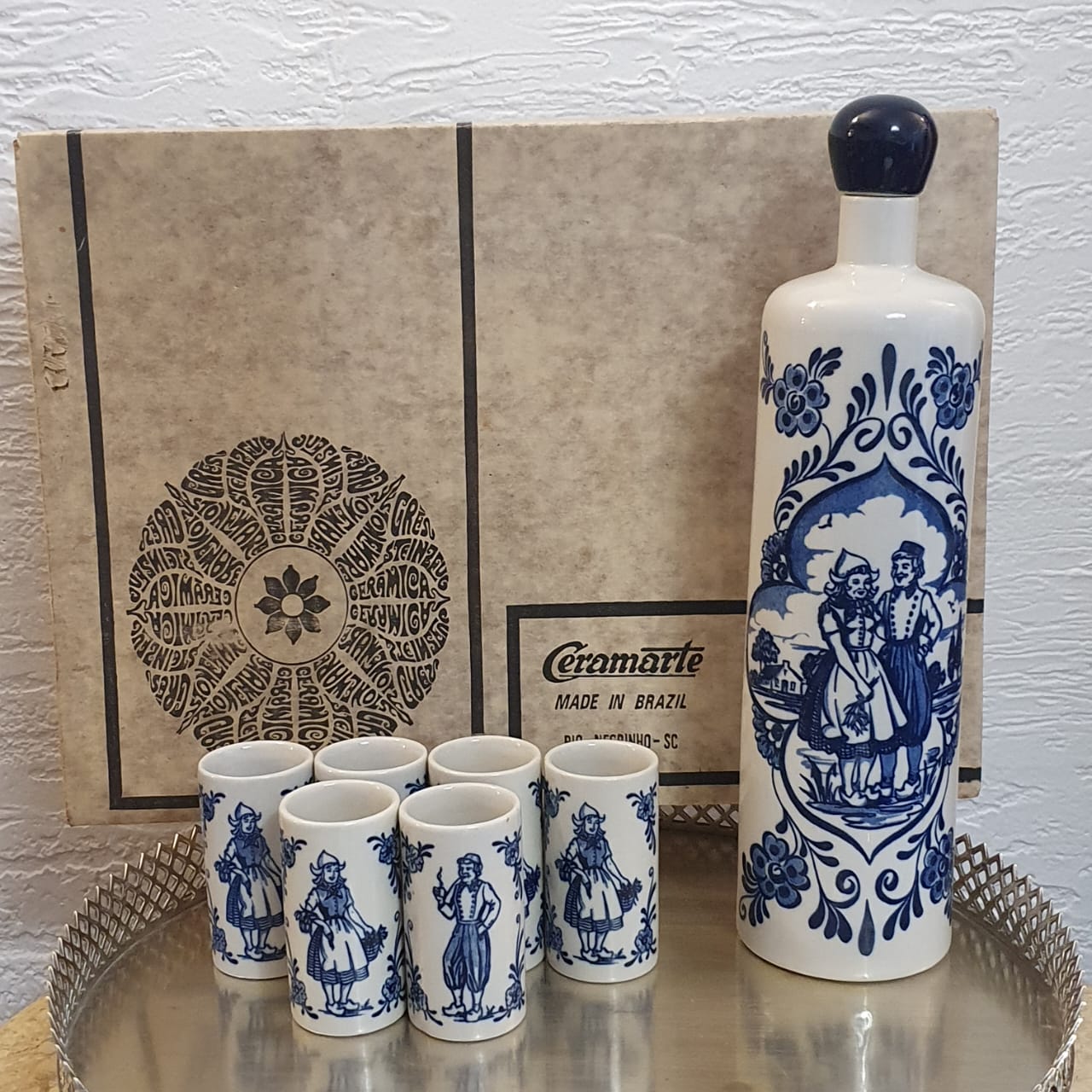Garrafa licoreira com 6 copinhos em porcelana Ceramarte azul e branco com pintura holandesa, modelo: holandês. 
