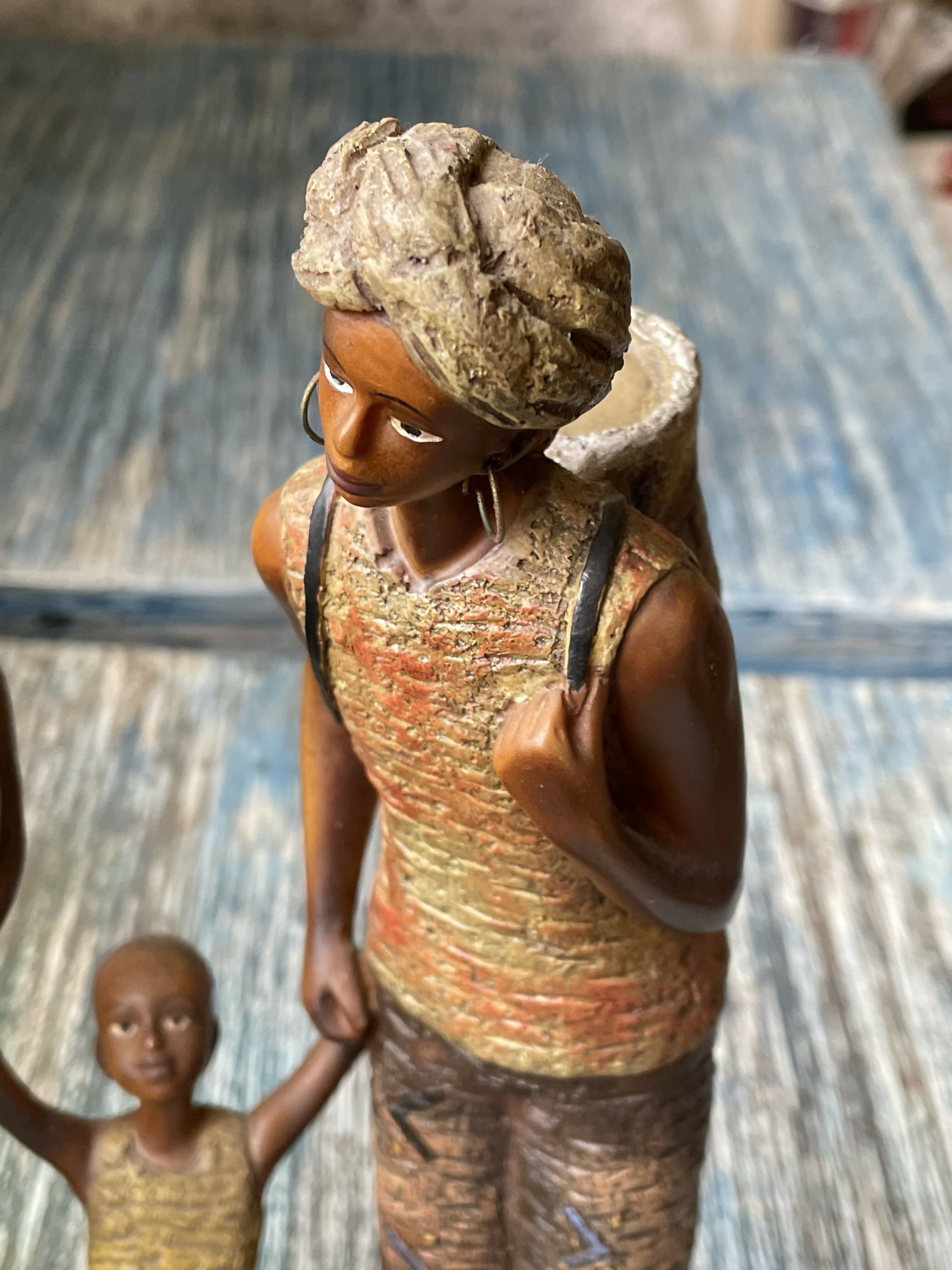 Estatueta em resina retratando família tribal