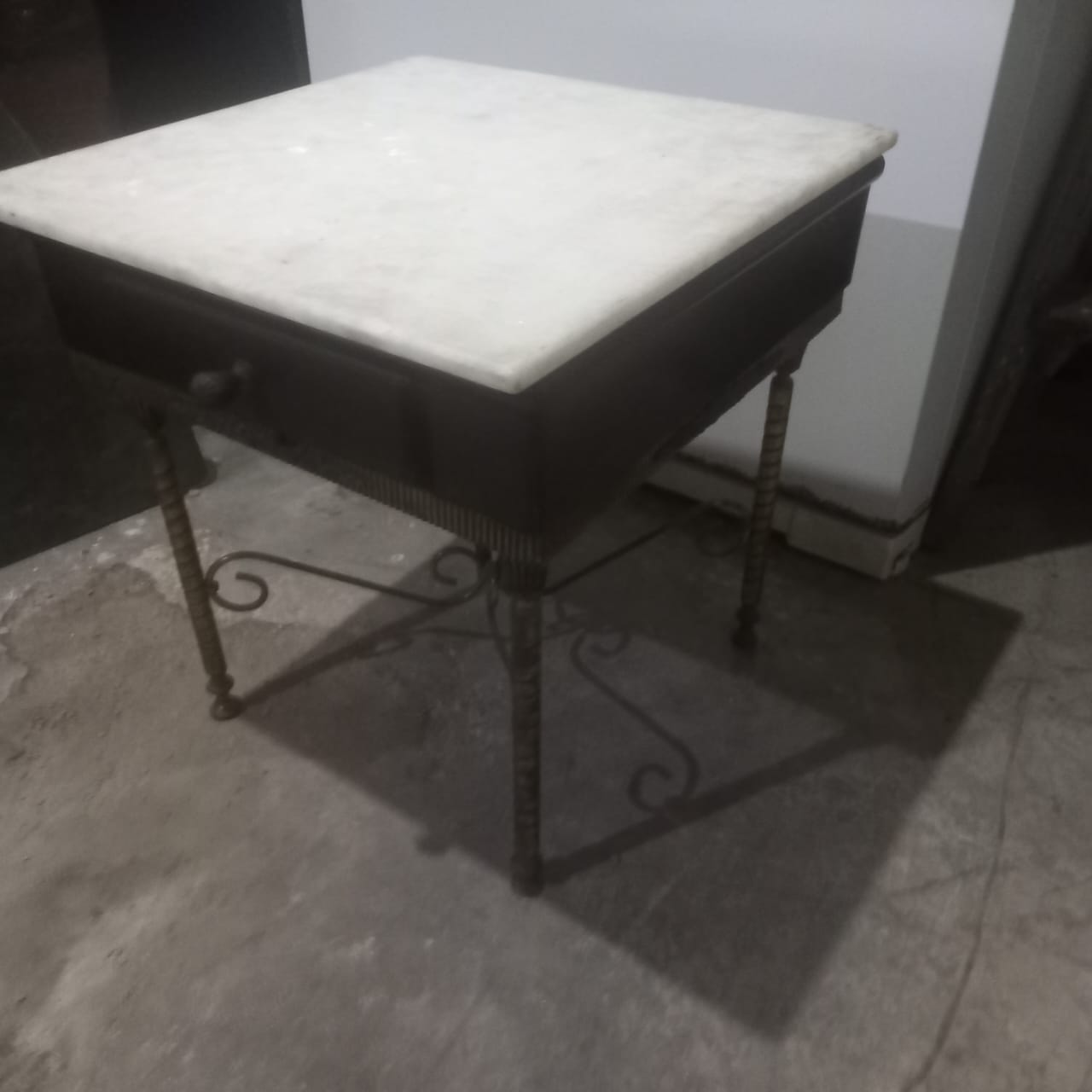 Mesa de cabeceira preta com pés em ferro e tampo em pedra 