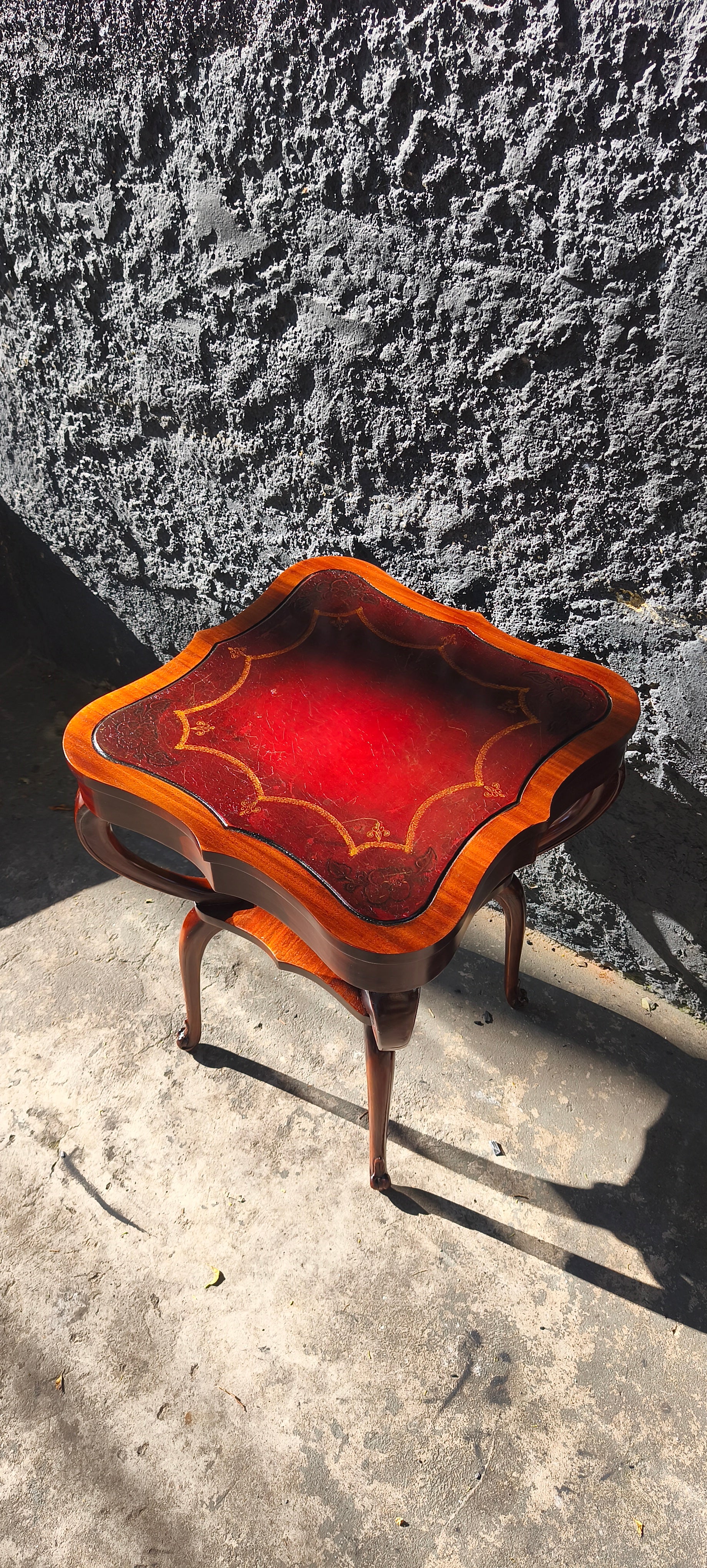Mesa auxiliar quadrada com tampo em couro vermelho com detalhes florais e pernas torneadas